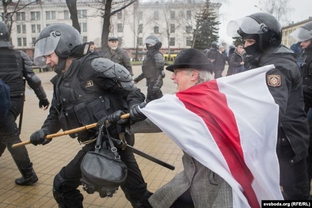 Правоохоронці у Мінську забирають прапор у активістки під час Дня волі у 2017 році
