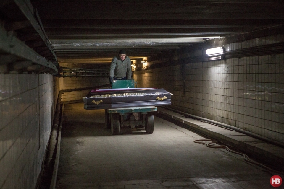 Працівники Київського крематорію доправляє труну до холодильної зали та печей. Цей коридор з'єднує прощальні зали та печі.