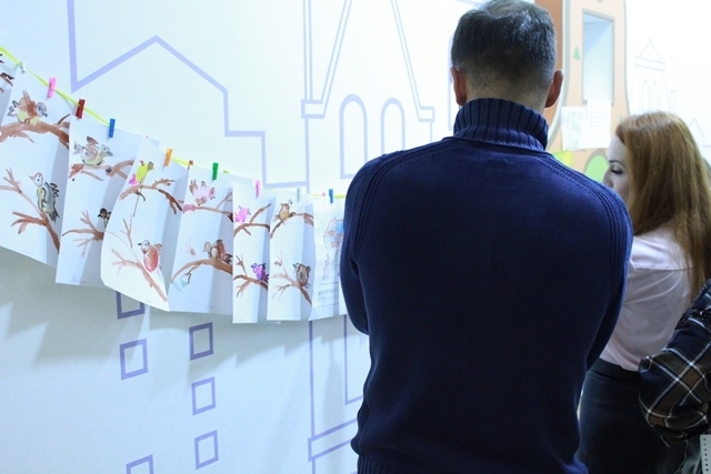 Гості оглядають тематичні дитячі малюнки. В закладі є окремі кімнати для творчості, де діти можуть сповна показати свої мистецькі здібності.