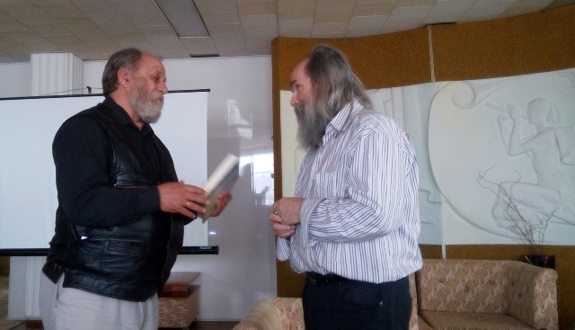 Автор реабілітаційної програми Віктор Гаврилюк (зліва) передає диски та книгу композитору Любомиру Мельнику.