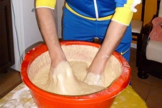 Руки Юрія Вознюка замішують тісто. Фото з Facebook.