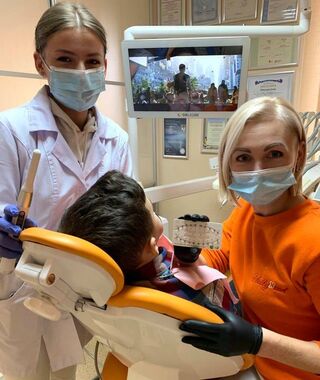 Інна Пекарська -  стоматолог що практикує, власниця клініки "Голлівуд".  Вона у помаранчевому светрі. Фото з відкритих джерел. 