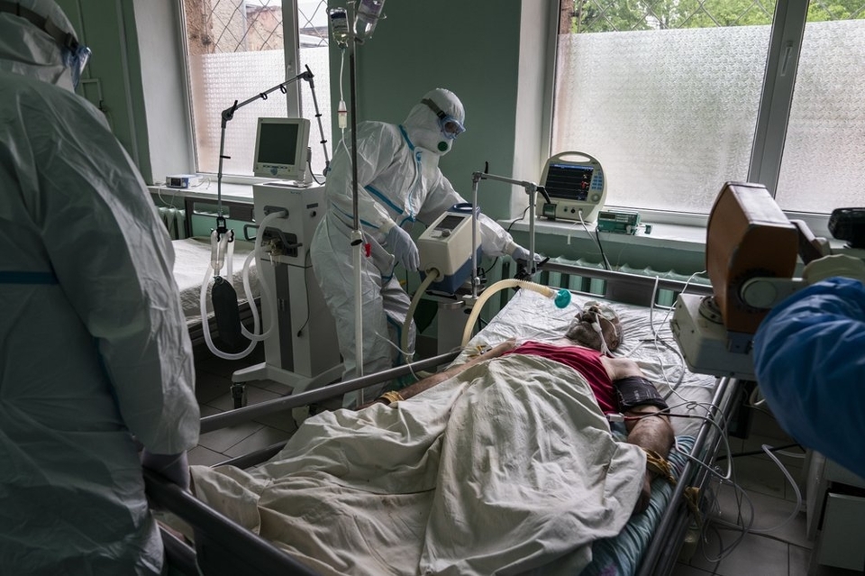 На цій фотографії, зробленій у понеділок, 4 травня 2020 року, лікарі, одягнені в спеціальні костюми для захисту від коронавірусу, готують пацієнта з коронавірусом до рентгенографії легенів у відділенні інтенсивної терапії в обласній лікарні в Чернівцях, У