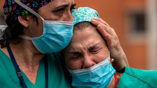 Фото ілюстративне. Associated Press. Іспанські медпрацівники плачуть під час встановлення меморіалу своєму колезі, який помер від коронавірусу.