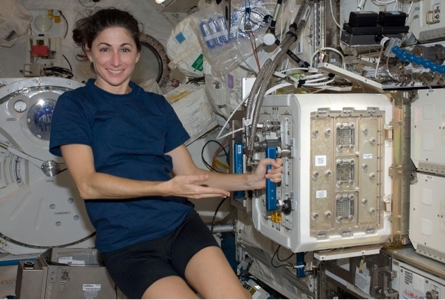 Астронавтка Ніколь Стотт демонструє контейнер на МКС де живуть миші