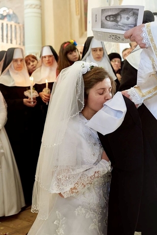Вона цілує свій майбутній монашеський одяг, який от-от зодягне на себе